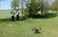 Dwaj policjanci przygotowują drona do startu