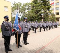 Poczet sztandarowy Komendy Wojewódzkiej Policji zs. w Radomiu na drugim planie nowo mianowani Policjanci
