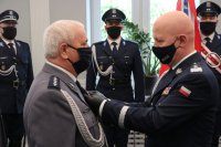 gen. insp. Jarosław Szymczyk Komendant Główny Policji przypina Złotą Odznakę „Zasłużony Policjant” asp. szt. Michałowi Strzałkowskiemu
