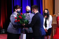 Cztery osoby na scenie, w tym policjantka przyjmująca kwiaty