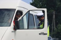 Policjant stojący obok białego samochodu