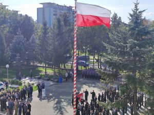 Plac, na którym stoją policjanci w mundurach oraz osoby cywilne