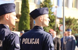 Plac, na którym stoją policjanci w mundurach oraz osoby cywilne