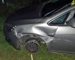 Rozbite auto stojące bez koła w rowie