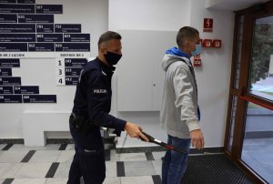 policjant sprawdza mężczyznę ręcznym wykrywaczem metali