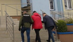 Zatrzymany mężczyzna prowadzony przez policjantów