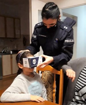 Policjantka zakłada dziecku okulary vr