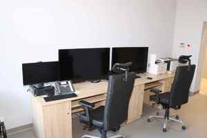 biurko z monitorami i krzesłami