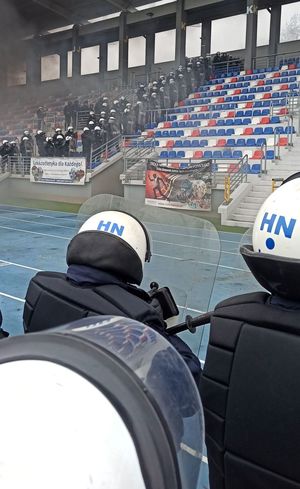 Umundurowani policjanci na trybunach stadionu sportowego