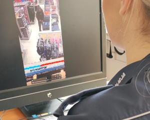 Umundurowana policjantka oglądająca na monitorze wnętrze sklepu