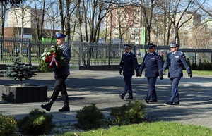 Umundurowani policjanci stojący przed pomnikiem