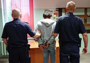 Zatrzymany mężczyzna prowadzony przez policjantów