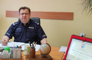 policjant siedzący za biurkiem