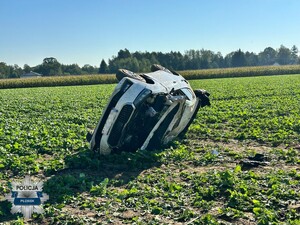 Zdjęcie przedstawia rozbity, biały samochód osobowy marki Skoda po wypadku drogowym (dachowaniu)