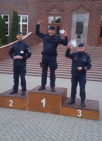 Umundurowani policjanci stojący na podium