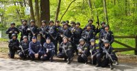 Umundurowani policjanci stojący w lesie