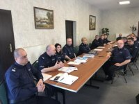 Umundurowani policjanci siedzący za stołem