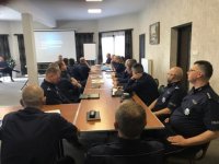 Umundurowani policjanci siedzący za stołem