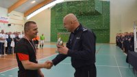 Policjant wręczający puchar za udział w turnieju