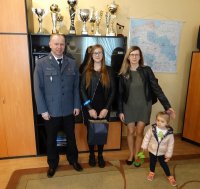 Laureatka konkursu z rodziną oraz Komendant Powiatowy Policji w Pułtusku mł. insp. Jarosław Olszewski, podczas wręczania nagrody za wiersz pt. 100-lecie Policji