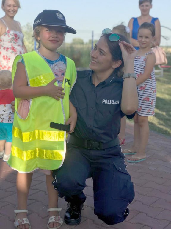 Umundurowana policjantka obok dziecka w kamizelce