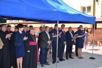 Umundurowani policjanci oraz osoby cywilne stojące pod namiotem