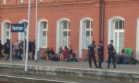 Policjanci oraz osoby cywilne stojące na peronie dworca kolejowego