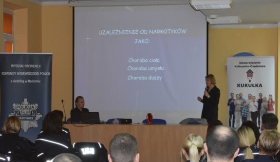 Umundurowani policjanci siedzący na sali wykładowej