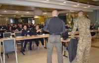 Umundurowani policjanci siedzący na sali wykładowej