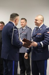 Umundurowani policjanci stojący na sali konferencyjnej