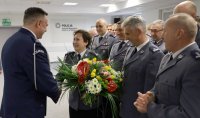 Umundurowani policjanci stojący na sali konferencyjnej