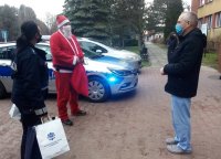 Mikołaj wraz z policjantką i ordynatorem obok policyjnego radiowozu przed Szpitalem Powiatowym w Kozienicach