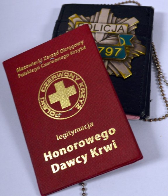 Książeczka zdrowia leżąca obok legitymacji policyjnej