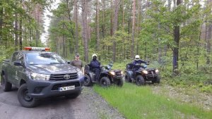 stojące quady i pojazd straży leśnej z funkcjonariuszami