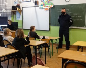 policjant prowadzi prelekcję w szkole podstawowej w Strykowicach Górnych na temat bezpiecznych ferii