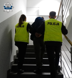 1 policjantka i 1 policjant wprowadzają do Komendy Powiatowej Policji w Zwoleniu zatrzymanego mężczyznę