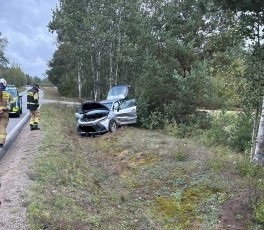 w rowie uszkodzony samochód osobowy na ulicy oznakowany radiowóz policyjny i dwóch strażaków