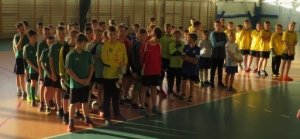 stojący młodzi piłkarze na zbiórce w sali gimnastycznej
