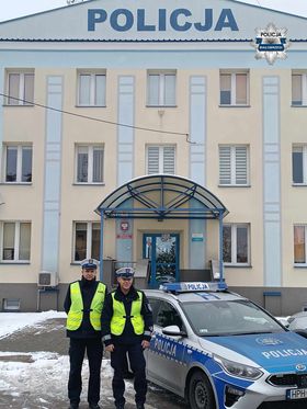 policjanci na tle radiowozu i budynku Komendy Powiatowej Policji w Białobrzegach