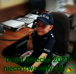 Dziecko w policyjnym mundurze, siedzące przy biurku ze słuchawką telefonu przy uchu. Napis Dzień Dziecka 2021. Niech trwa cały rok.