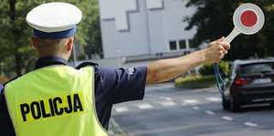 umundurowany policjant wydaje tarczą sygnał do zatrzymania