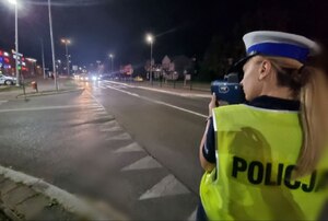 Policjanta mierzy prędkość laserowym miernikiem prędkości