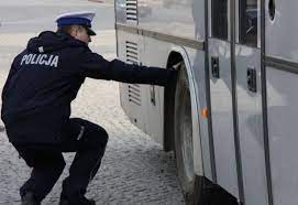 Policjant kontroluje stan techniczny autobusu