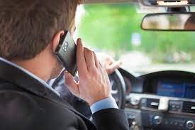 mężczyzna trzyma w ręku telefon podczas jazdy