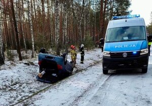 Samochód leżący na dachu, obok radiowóz policyjny - fot. OSP Dylewo