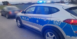 Na zdjęciu zatrzymany pojazd do kontroli, z tyłu radiowóz policyjny