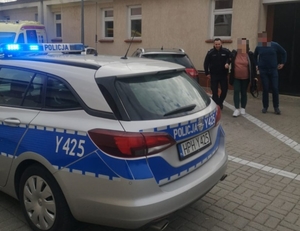 policjant prowadzący kobietę w ciąży do wejścia do szpitala