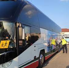 Policjant kontroluje stan techniczny autobusu szkolnego