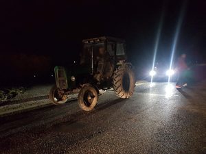 Ciągnik rolniczy bez oświetlania stoi na drodze - zdjęcie poglądowe
