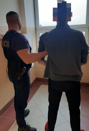 Policjant wykonuje czynności z zatrzymanym